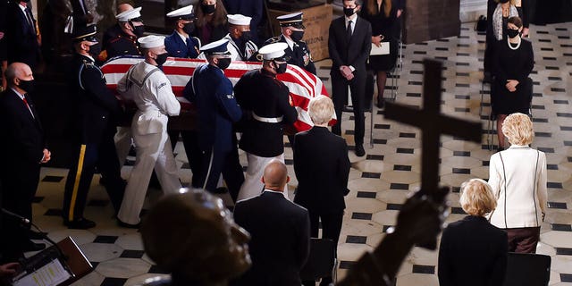 A joint services military honor guard carries the flag-draped casket of Justice Ruth Bader Ginsburg to lie in state in Statuary Hall of the U.S. Capitol, Friday, Sept. 25, 2020, in Washington. (Olivier Douliery/Pool via AP)