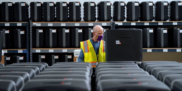 In this Sept. 3, 2020, file photo, a worker prepares tabulators for the upcoming election at the Wake County Board of Elections in Raleigh, N.C. (AP Photo/Gerry Broome, file)