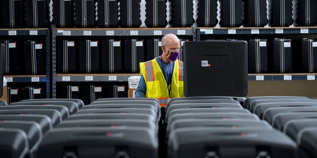 In this Sept. 3, 2020, file photo, a worker prepares tabulators for the upcoming election at the Wake County Board of Elections in Raleigh, N.C. (AP Photo/Gerry Broome, file)