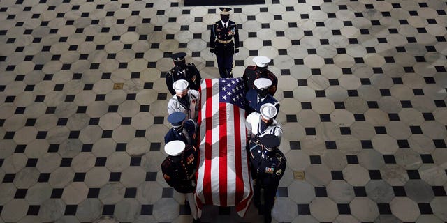 The flag-draped casket of Justice Ruth Bader Ginsburg is carried out of the Statuary Hall by a joint services military honor guard after Ginsburg lied in state Sept. 25, in Washington. (Chip Somodevilla/Pool via AP)