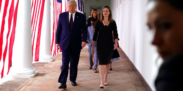 President Donald Trump walks along the Colonnade with Judge Amy Coney Barrett after a news conference to announce Barrett as his nominee to the Supreme Court, in the Rose Garden at the White House, Sept. 26, in Washington.