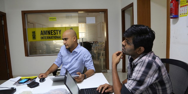 FILE - In this Tuesday, Feb. 5, 2019, file photo, Amnesty International India employees work at their headquarters in Bangalore, India. (AP Photo/Aijaz Rahi, File)