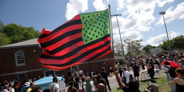 A stylized American Black Lives Matter flag flies during a Juneteenth rally, Friday, June 19, 2020, in Boston. Juneteenth commemorates when the last enslaved African Americans learned in 1865 they were free, more than two years following the Emancipation Proclamation. (AP Photo/Michael Dwyer)