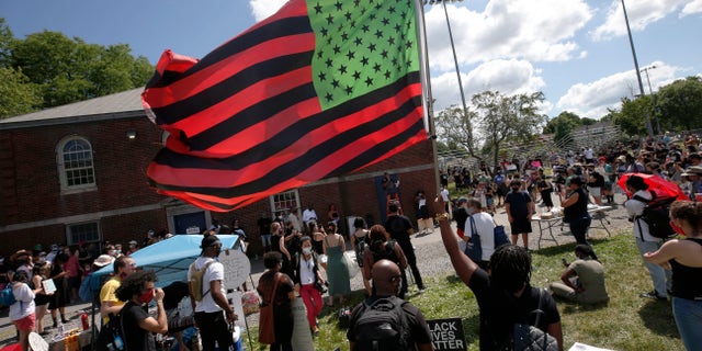 A stylized American Black Lives Matter flag flies during a Juneteenth rally, Friday, June 19, 2020, in Boston. Juneteenth commemorates when the last enslaved African Americans learned in 1865 they were free, more than two years following the Emancipation Proclamation. (AP Photo/Michael Dwyer)