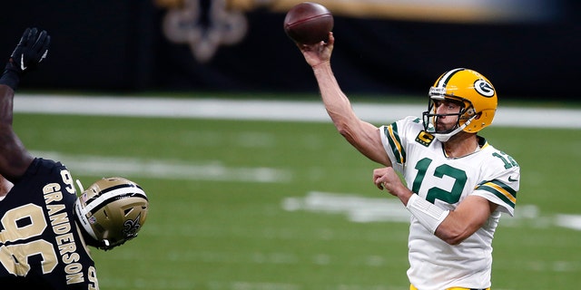 Green Bay Packers quarterback Aaron Rodgers (12) passes under pressure from New Orleans Saints defensive end Carl Granderson (96) in the first half of an NFL football game in New Orleans, Sunday, Sept. 27, 2020. (AP Photo/Butch Dill)