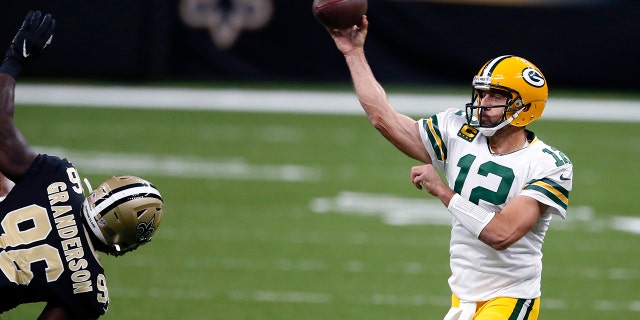 Green Bay Packers quarterback Aaron Rodgers (12) passes under pressure from New Orleans Saints defensive end Carl Granderson (96) in the first half of an NFL football game in New Orleans, Sondag, Sept.. 27, 2020. (AP Photo/Butch Dill)