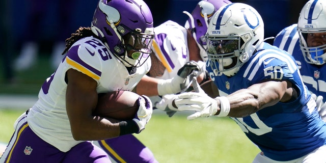 Minnesota Vikings' Alexander Mattison (25) runs past Indianapolis Colts' Justin Houston (50) during the first half of an NFL football game, Sunday, Sept. 20, 2020, in Indianapolis. (AP Photo/Michael Conroy)