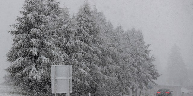 A car makes his way through heavy snow on motorway A 13 in Noesslach near Innsbruck, Austria, Friday, Sept. 25, 2020.