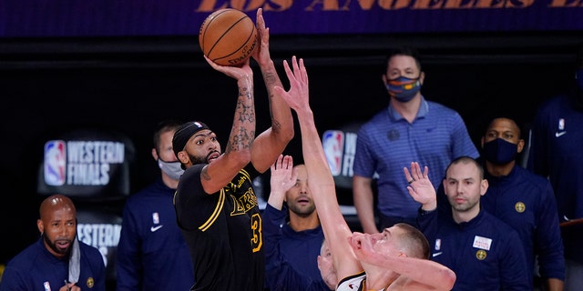Los Angeles Lakers' Anthony Davis (3) shoots a 3-point basket over Denver Nuggets' Nikola Jokic (15) at the end of an NBA conference final playoff basketball game Sunday, Sept. 20, 2020, in Lake Buena Vista, Fla. The Lakers won 105-103. (AP Photo/Mark J. Terrill)