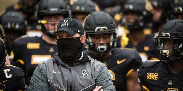 Appalachian State coach Shawn Clark stands with his team prior to an NCAA college football game against Charlotte on Saturday, Sept. 12, 2020, in Boone, N.C. (Allison Lee Isley/The Winston-Salem Journal via AP)