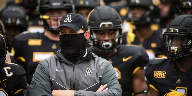 Appalachian State coach Shawn Clark stands with his team prior to an NCAA college football game against Charlotte on Saturday, Sept. 12, 2020, in Boone, N.C. (Allison Lee Isley/The Winston-Salem Journal via AP)