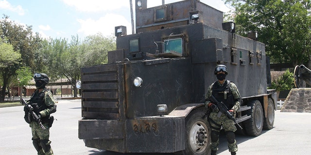 Soldiers stand guard in front of a modified and armored truck as it is displayed to the media at a military base in Reynosa, in the Mexican state of Tamaulipas June 5, 2011. Soldiers seized a couple of modified and armored trucks at a warehouse in the municipality of Camargo during a patrol on Saturday, local media reported. According to the military, the vehicles were used by the CDG (Gulf Cartel) to transport drugs and hitmen.