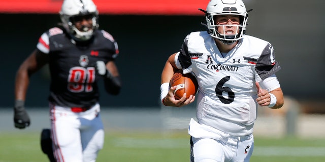 Cincinnati quarterback Ben Bryant, right, breaks away from the Austin Peay defense to score a touchdown during the second half of an NCAA college football game Saturday, Sept. 19, 2020, in Cincinnati, Ohio. Cincinnati beat Austin Peay 55-20. (AP Photo/Jay LaPrete)