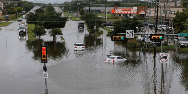 Vehicles are stranded at the intersection of Pearland and South Sam Houston parkways, Tuesday, Sept. 22, 2020, in Houston, following flooding from Tropical Storm Beta.
