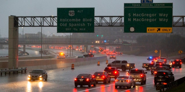 Cars turn around on southbound 288 because of a road blockage caused by Tropical Storm Beta flooding Tuesday, Sept. 22, 2020, in Houston.