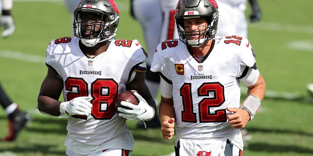 Tampa Bay Buccaneers running back Leonard Fournette (28) runs off the field with quarterback Tom Brady (12) after Fournette ran 46-yards for a score against the Carolina Panthers during the second half of an NFL football game Sunday, Sept. 20, 2020, in Tampa, Fla. (AP Photo/Mark LoMoglio)