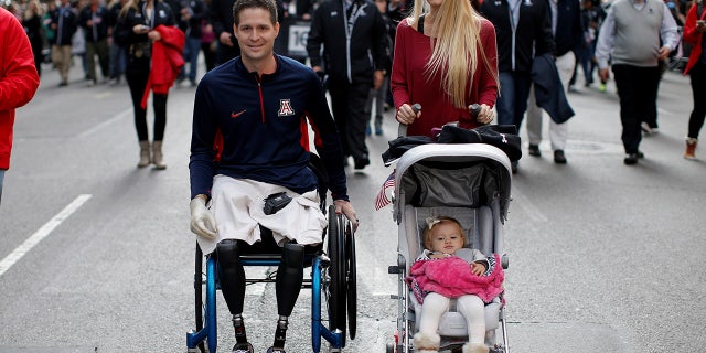 United States Air Force Senior Airman Brian Kolfage, a triple amputee who lost both his legs and an arm while serving his second deployment in Iraq in 2004, attends the Veterans Day parade with his wife Ashley in New York City in 2014. (로이터)