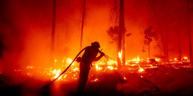 In this Sept. 7, 2020, file photo, a firefighter battles the Creek Fire as it threatens homes in the Cascadel Woods neighborhood of Madera County, Calif.