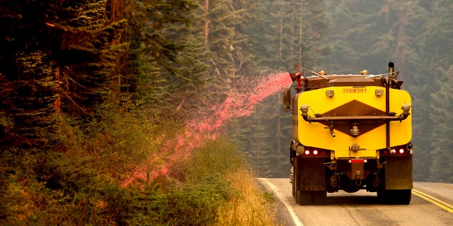 A truck sprays fire retardant on vegetation to help stop the spread of the North Complex Fire in Plumas National Forest, Calif., on Monday, Sept. 14, 2020.