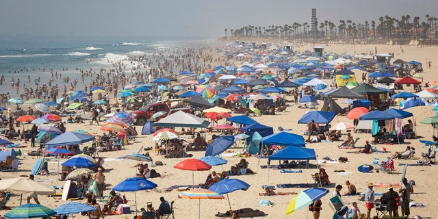 People escape the California heat wave at the beach, Sunday, Sept. 6, 2020, in Huntington Beach, Calif.