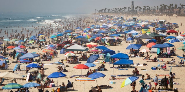 People escape the California heat wave at the beach, Sunday, Sept. 6, 2020, in Huntington Beach, Calif.