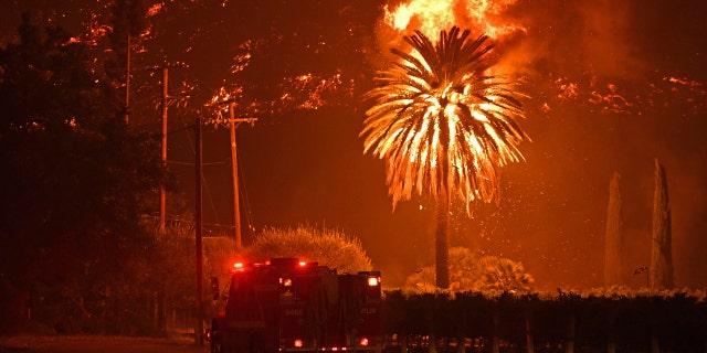 A firetruck travels on the Silverado Trail as a hillside goes up in flames during the Glass Fire in St. Helena, Calif., on Sunday, Sept. 27, 2020.