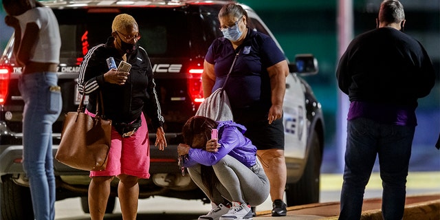 A woman kneels on the ground outside the University of Chicago Medicine's Comer Children's Hospital where a 8-year-old girl was taken after being killed in a shooting that wounded three others during the Labor Day weekend Monday Sep. 7, 2020 in Chicago. (Armando L. Sanchez/Chicago Tribune/Tribune News Service via Getty Images)