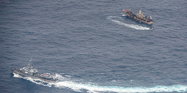 Ecuadorian Navy vessels surround a fishing boat after detecting a fishing fleet of mostly Chinese-flagged ships in an international corridor that borders the Galapagos Islands' exclusive economic zone, in the Pacific Ocean, August 7, 2020. Picture taken August 7, 2020. REUTERS/Santiago Arcos - RC2EAI9QEFR7