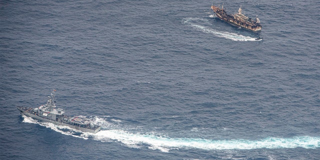 Ecuadorian Navy vessels surround a fishing boat after detecting a fishing fleet of mostly Chinese-flagged ships in an international corridor that borders the Galapagos Islands' exclusive economic zone, in the Pacific Ocean, August 7, 2020. Picture taken August 7, 2020. REUTERS/Santiago Arcos - RC2EAI9QEFR7