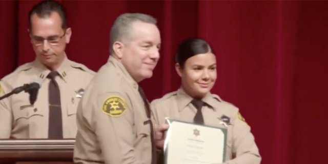 Claudia Apolinar smiling for a photo with LASD Sheriff Alex Villanueva at her July 2019 graduation (Los Angeles County Sheriff's Department Facebook)