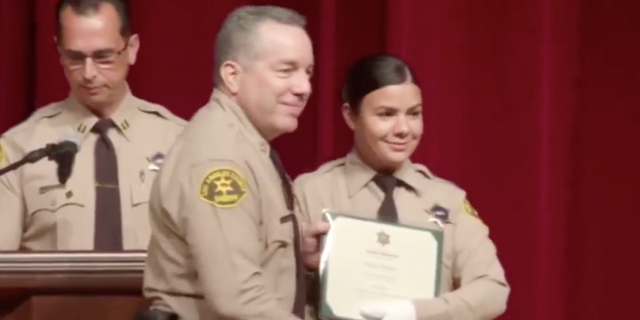 Claudia Apolinar smiling for a photo with LASD Sheriff Alex Villanueva at her July 2019 graduation (Los Angeles County Sheriff's Department Facebook)