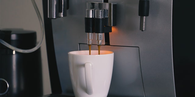 Closeup espresso coffee machine. Automatic coffee maker with cup of cappuccino domestic household appliances