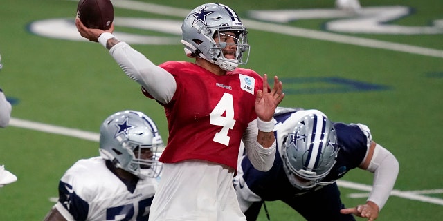 Dallas Cowboys quarterback Dak Prescott (4) passes against defender DeMarcus Lawrence (90) during an NFL football training camp practice in Frisco, Texas, Monday, Aug. 31, 2020. (AP Photo/LM Otero)