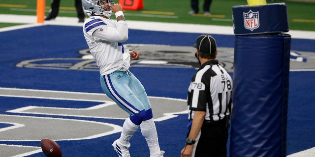 Dallas Cowboys quarterback Dak Prescott (4) celebrates running the ball for a touchdown as back judge Greg Meyer (78) looks on in the second half of an NFL football game against the Atlanta Falcons in Arlington, Texas, Sunday, Sept. 20, 2020. (AP Photo/Ron Jenkins)