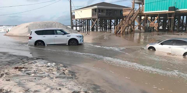 This photo provided by Dauphin Island Mayor Jeff Collier shows cars stranded in the sand, as flooding continues in Tonty Court on Dauphin Island, Ala., Monday, Sept 14, 2020, as Sally closes in on the Gulf Coast.
