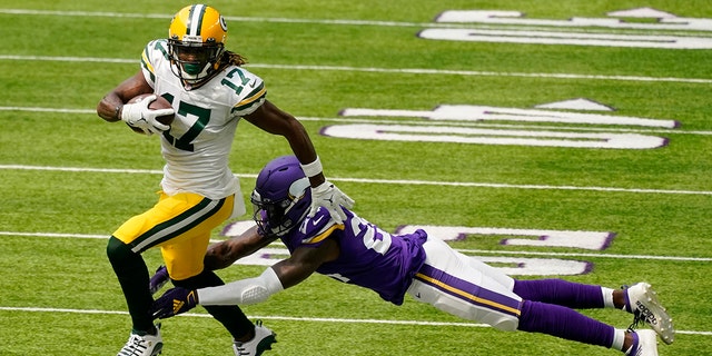 Green Bay Packers wide receiver Davante Adams breaks a tackle by Minnesota Vikings defensive back Holton Hill (24) during the first half of an NFL football game, Sunday, Sept. 13, 2020, in Minneapolis. (AP Photo/Jim Mone)