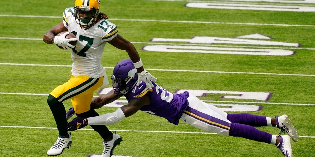 Green Bay Packers wide receiver Davante Adams breaks a tackle by Minnesota Vikings defensive back Holton Hill (24) during the first half of an NFL football game, Sunday, Sept. 13, 2020, in Minneapolis. (AP Photo/Jim Mone)