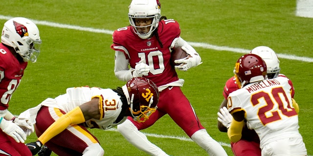 Arizona Cardinals wide receiver DeAndre Hopkins (10) tries to elude Washington Football Team safety Kamren Curl (31) during the first half of an NFL football game, Sunday, Sept. 20, 2020, in Glendale, Ariz. (AP Photo/Ross D. Franklin)