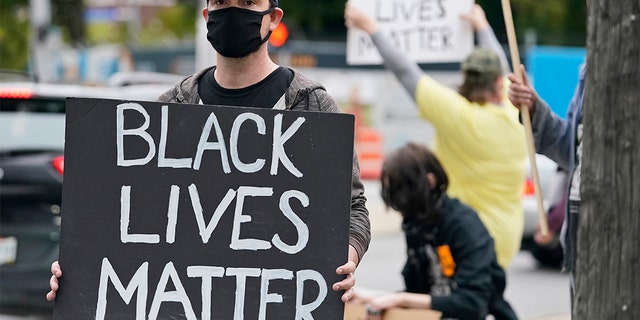 A protester holds up a Black Lives Matter sign near the debate hall, Tuesday, Sept. 29, 2020, in Cleveland. The first presidential debate between Republican candidate President Donald Trump and Democratic candidate and former Vice President Joe Biden is being held in Cleveland Tuesday. (AP Photo/Tony Dejak)