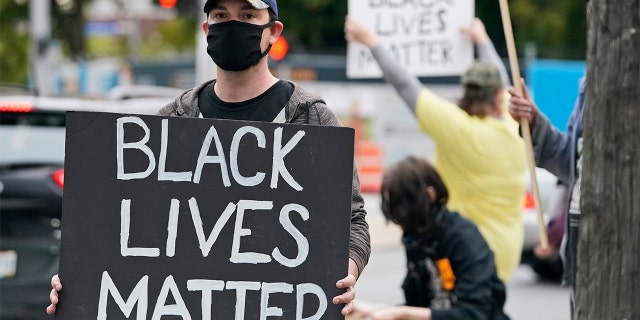 A protester holds up a Black Lives Matter sign near the debate hall, Tuesday, Sept. 29, 2020, in Cleveland. The first presidential debate between Republican candidate President Donald Trump and Democratic candidate and former Vice President Joe Biden is being held in Cleveland Tuesday. (AP Photo/Tony Dejak)