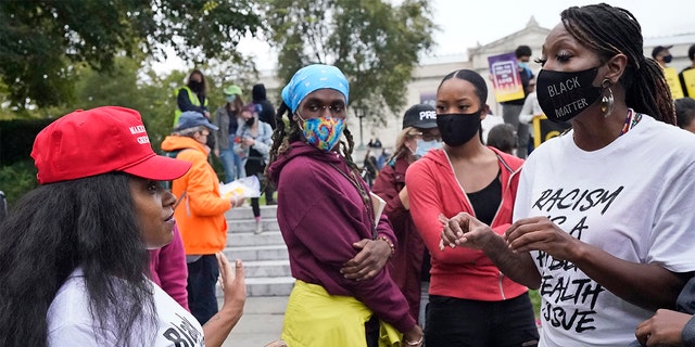 A Trump supporter and a protester argue near the debate hall, Tuesday, Sept. 29, 2020, in Cleveland. The first presidential debate between Republican candidate President Donald Trump and Democratic candidate and former Vice President Joe Biden is being held in Cleveland Tuesday. (AP Photo/Tony Dejak)