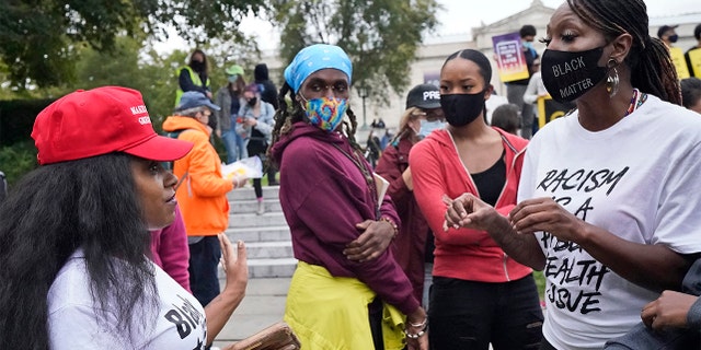A Trump supporter and a protester argue near the debate hall, Tuesday, Sept. 29, 2020, in Cleveland. The first presidential debate between Republican candidate President Donald Trump and Democratic candidate and former Vice President Joe Biden is being held in Cleveland Tuesday. (AP Photo/Tony Dejak)