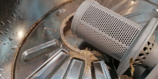 A dirty filter is shown pulled out of the inside of a dishwasher. (iStock)