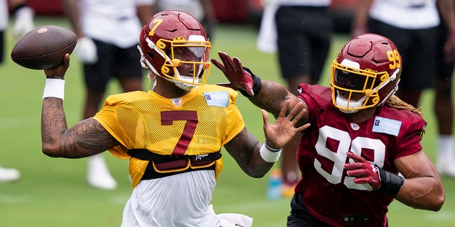 Washington quarterback Dwayne Haskins Jr. (7) passes under pressure from defensive end Chase Young (99) during an NFL football practice at FedEx Field, Monday, Aug. 31, 2020, in Washington. (AP Photo/Alex Brandon)