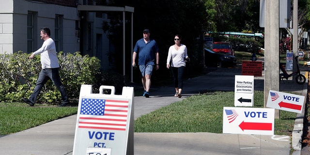 In this March 17, photo, voters head to a polling station to vote in Florida's primary election in Orlando, Fla. Florida felons must pay all fines, restitution and legal fees before they can regain their right to vote, a federal appellate court ruled Sept, 11. (AP Photo/John Raoux, File)