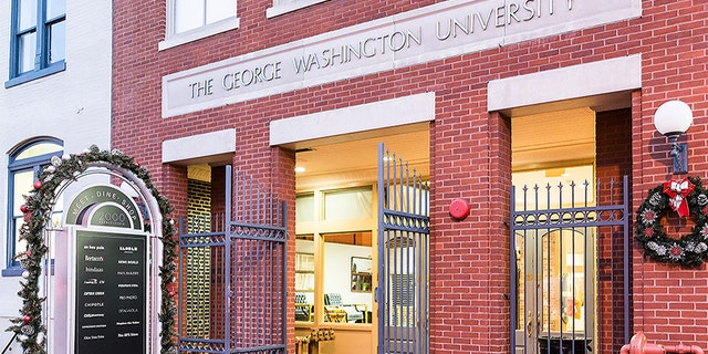 Washington DC, USA - December 28, 2017: George Washington University Center with sign, entrance, red brick building in evening, holiday winter decorations, lights