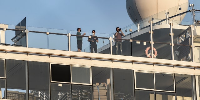Passengers of the Mein Schiff 6 cruise ship stand outside their cabins as the ship is docked at Piraeus port, near Athens on Sept. 29. (Dimitris Lampropoulos/NurPhoto via Getty Images)