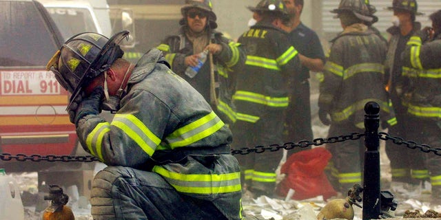 A firefighter breaks down after the World Trade Center buildings collapsed September 11, 2001 after two hijacked airplanes slammed into the twin towers in a terrorist attack. (Photo by Mario Tama/Getty Images)