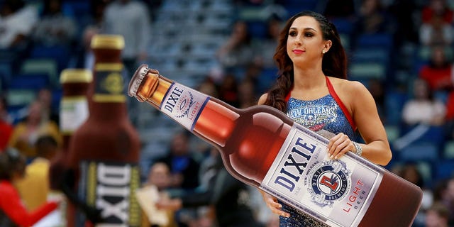 A New Orleans Pelicans cheerleader holds a Dixie beer during the first half of a NBA game between the Charlotte Hornets and the New Orleans Pelicans in March 2018.(Photo by Sean Gardner/Getty Images)