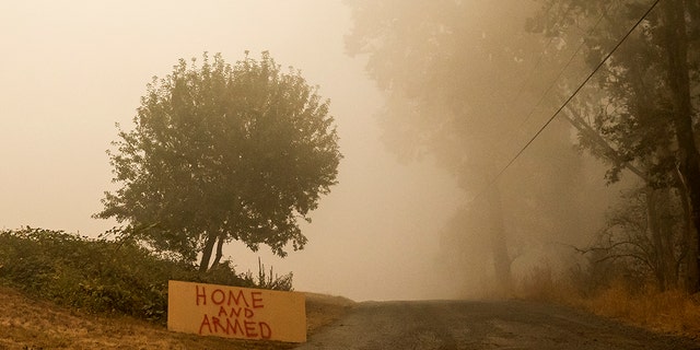 SUBLIMITY, OR - SEPTEMBER 13: A sign warns against looters as heavy smoke fills the air on September 13, 2020 in Sublimity, Oregon. Multiple wildfires grew by hundreds of thousands of acres this week forcing evacuations and road closures. (Photo by Nathan Howard/Getty Images)